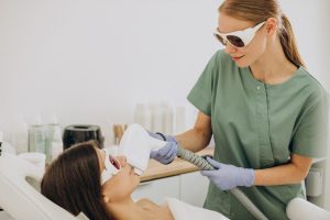 A professional conducts laser hair removal course San Antonio, using a device on a client in a clinical setting.