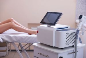 Technician performs leg treatment using IPL device at top-rated laser hair removal school San Antonio training session