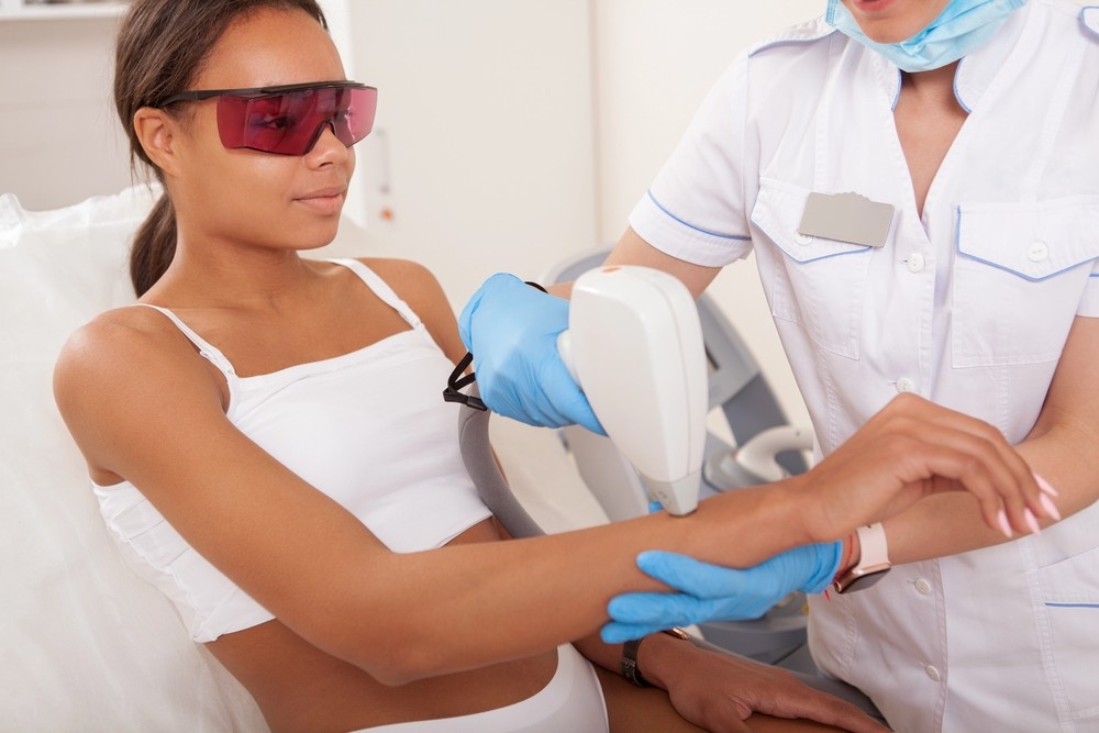 Laser hair removal school San Antonio student performing forearm laser treatment on client in a professional clinical setting.