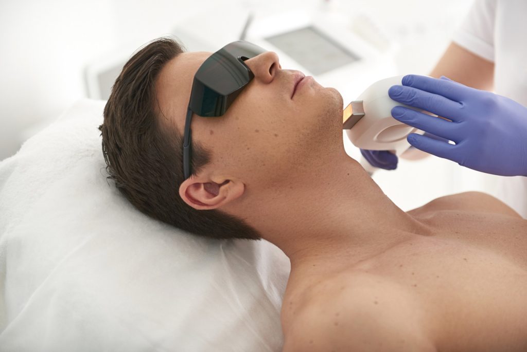 Male facial grooming training at a laser hair removal school Woodlands clinic showing precise chin and neck treatment.