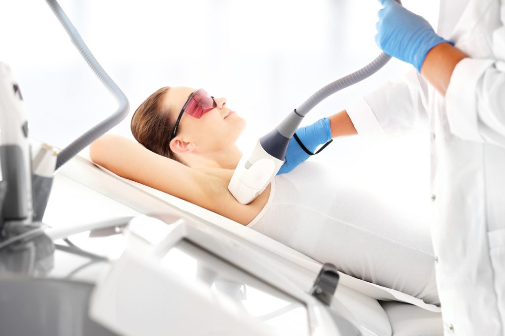 Specialist performing underarm treatment to earn a laser hair removal certification at a professional medical spa.