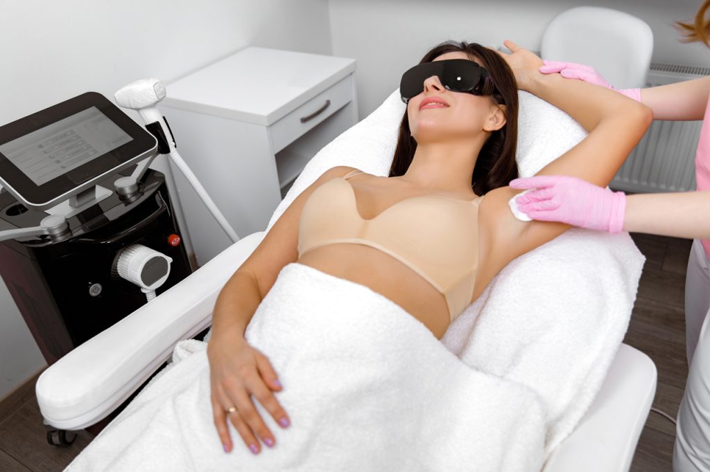 Professional laser hair removal technician training Woodlands student cleans underarm area for a diode laser session.