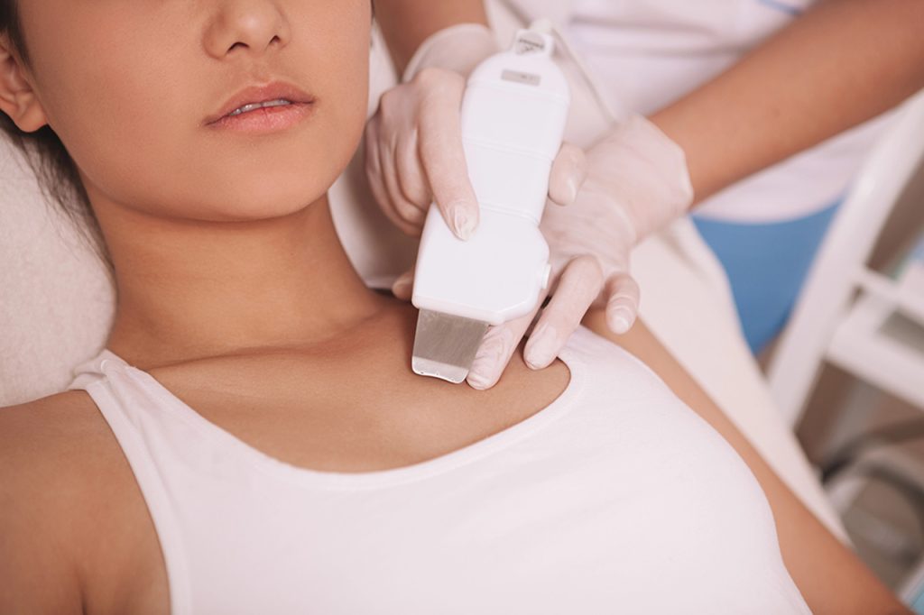 Student at a certified laser technician school near me Woodlands performs a professional facial skin treatment.