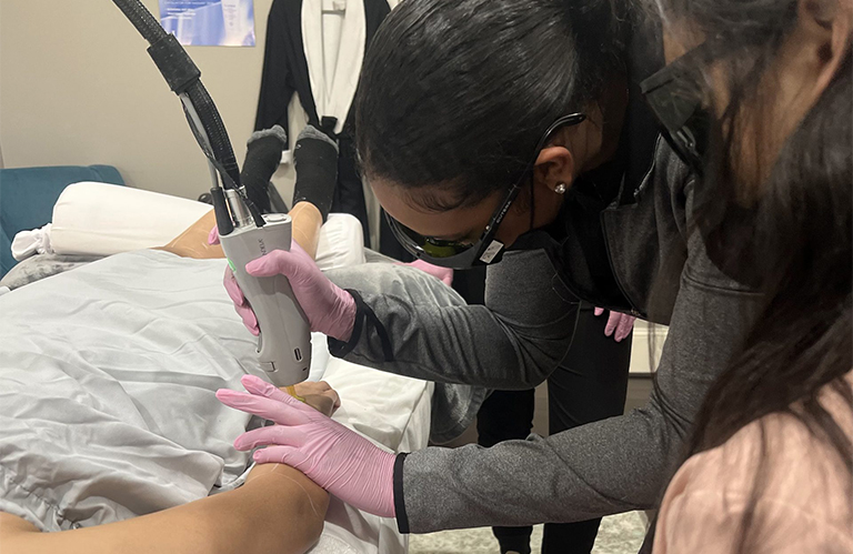 Expert instruction during a laser hair removal technician certification woodlands course using medical-grade lasers.