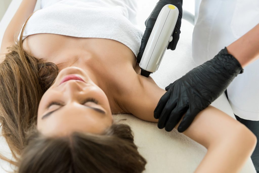 Certified technician uses advanced equipment for underarm care during a laser hair removal certification course.