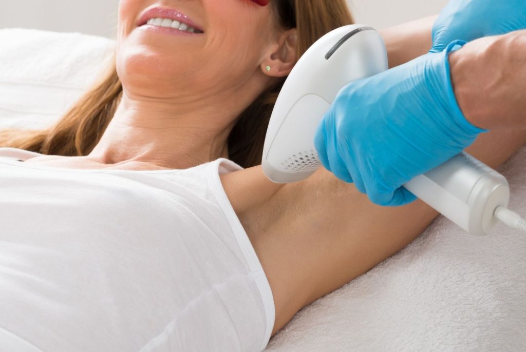 Professional laser hair removal course Woodlands student performing underarm treatment on a female client.