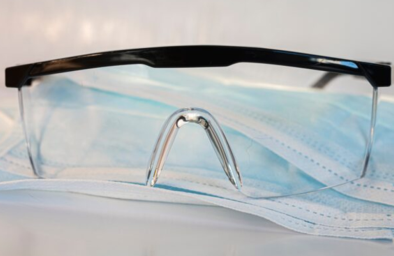A close-up of clinical safety goggles and medical masks, representing the safety-first approach of nearby laser certification programs.