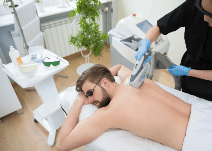 Laser hair removal technician certification Woodlands training showing a professional treating a man's back.