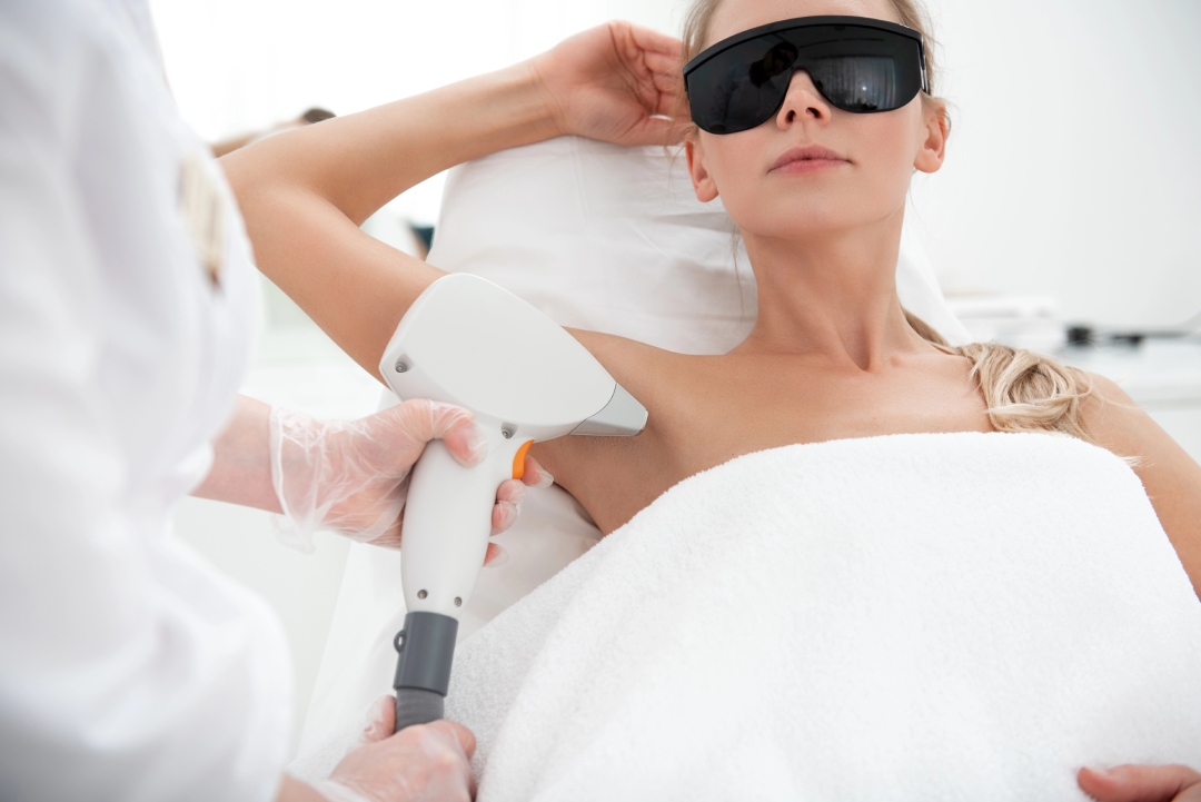 Professional laser hair removal training Woodlands session demonstrating underarm treatment with high-tech laser device.