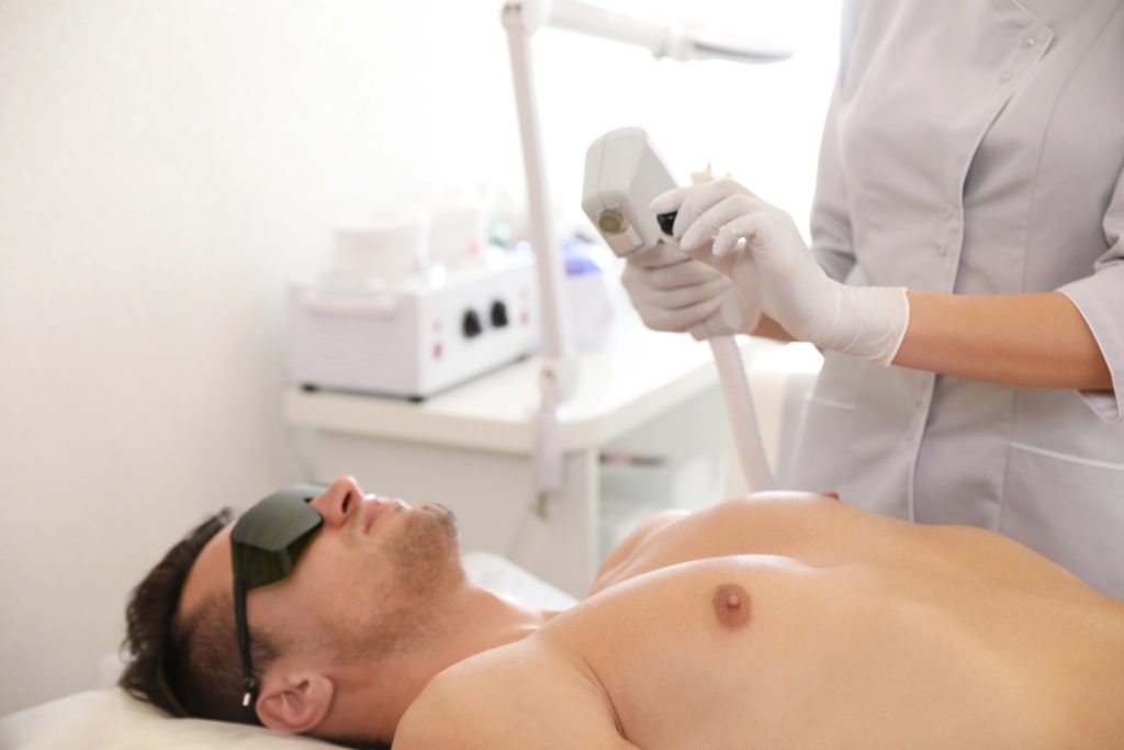 Professional male chest treatment during a laser hair removal training Woodlands course for aspiring technicians.