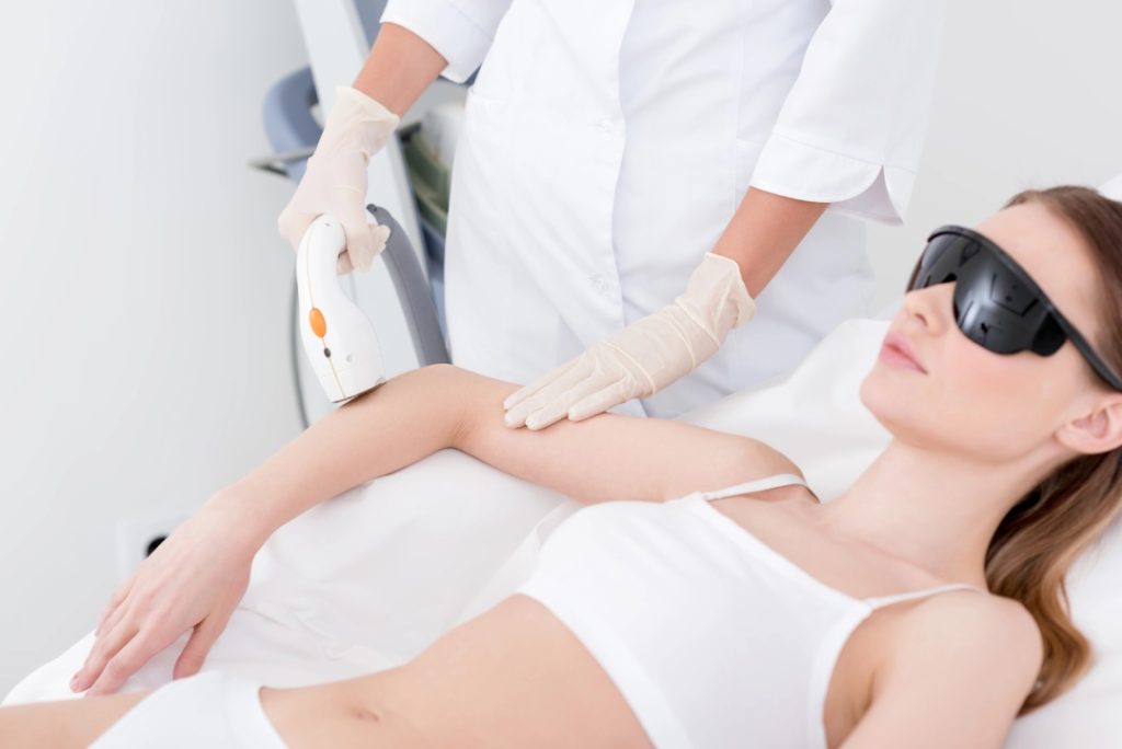 A student practices arm techniques during laser hair removal training Woodlands using professional aesthetic equipment.