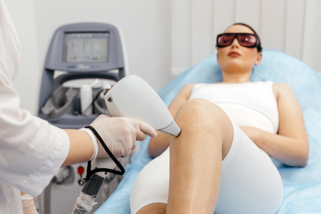 Professional laser technician performing laser hair removal on leg in Woodlands, certified school near me.