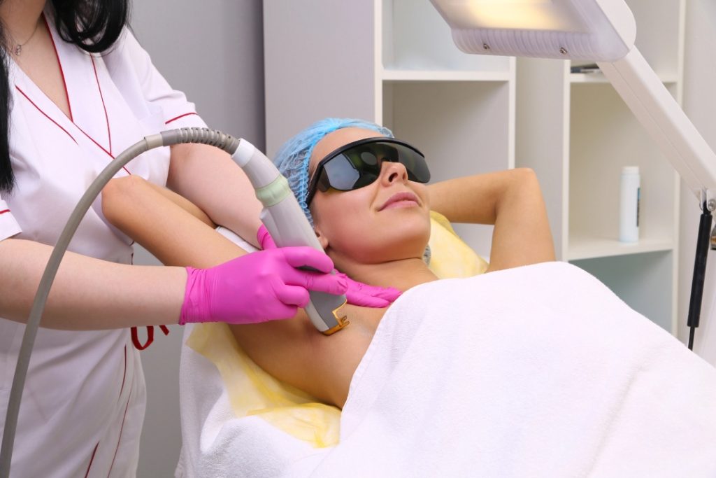 Hands-on laser hair removal training Woodlands featuring professional technician treating underarm area on student.