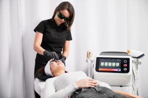 A professional esthetician preps a client for a facial procedure, highlighting key laser hair removal education facts.