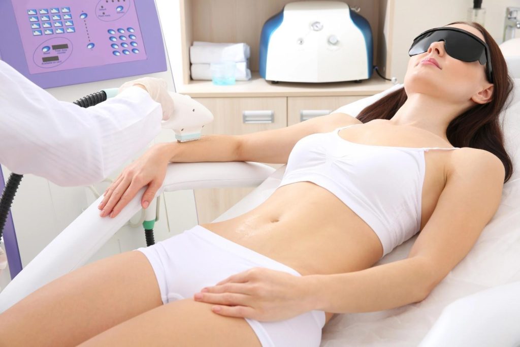 Laser hair removal education showing a woman receiving a professional forearm treatment in a clinical setting.