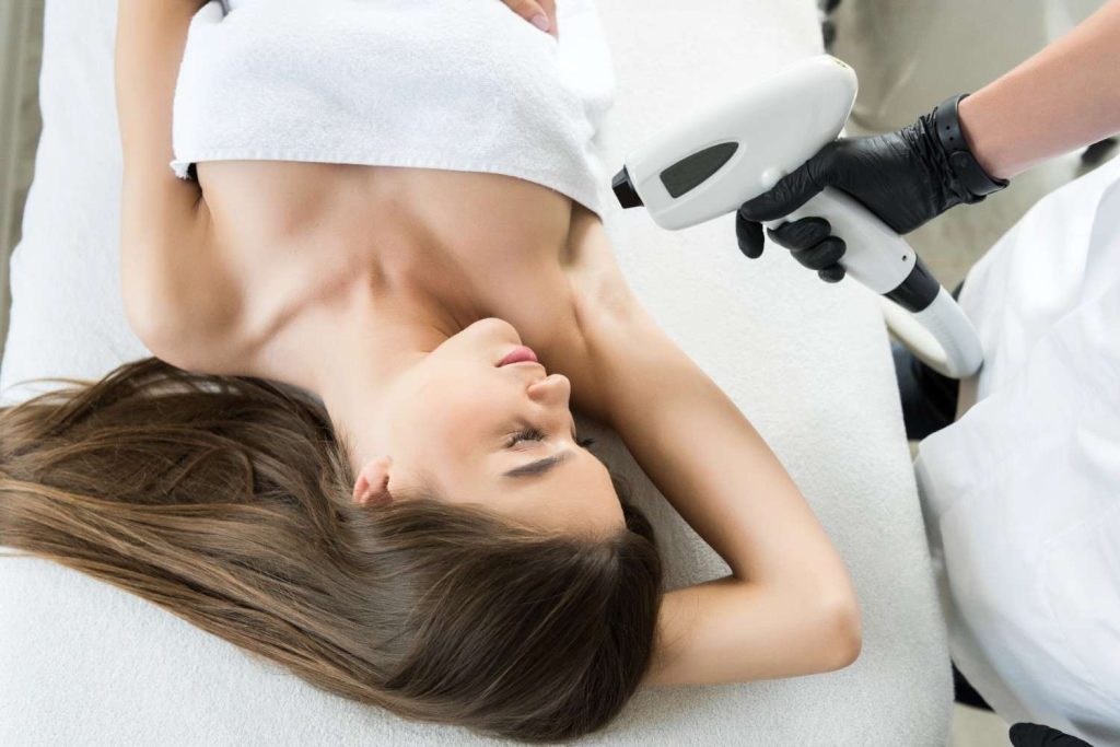 Professional laser hair removal training showing an expert underarm treatment procedure in a clinic. 