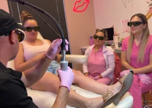 Students observe a clinical leg treatment during a Corpus Christi laser hair removal hands-on training workshop.