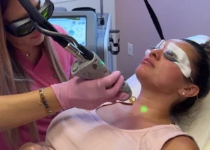 Specialist treating a client's neck with cosmetic equipment during Dallas laser hair removal hands-on training.