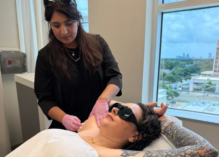 Specialist prepping a tattooed client's underarm during an El Paso laser hair removal hands-on training session.